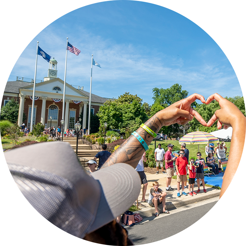A person making a heart gesture in downtown Fairfax